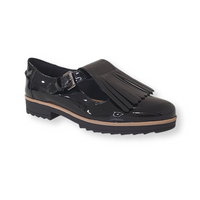 Black patent leather loafer with fringe detail, buckle strap and chunky sole