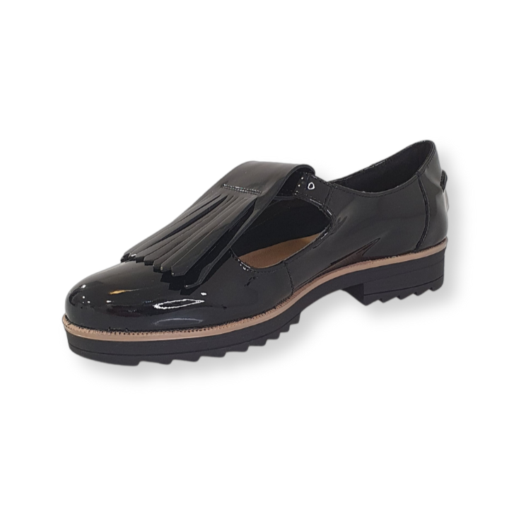 Black patent leather loafer with fringe detail and low heel on black background