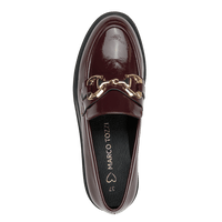A single dark burgundy patent leather loafer by Marco Tozzi, featuring a gold horsebit detail across the vamp, shown from a top-down view against a solid green background.