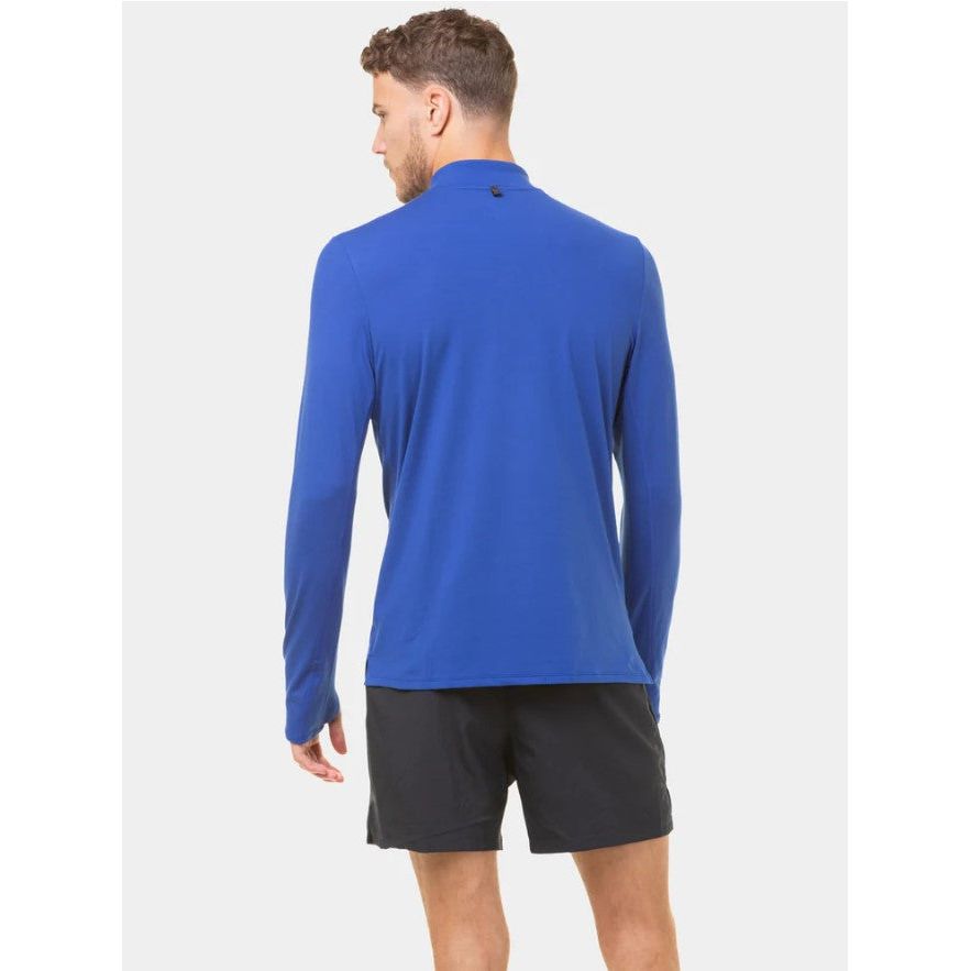 Man wearing cobalt blue long sleeve athletic top and black shorts, back view