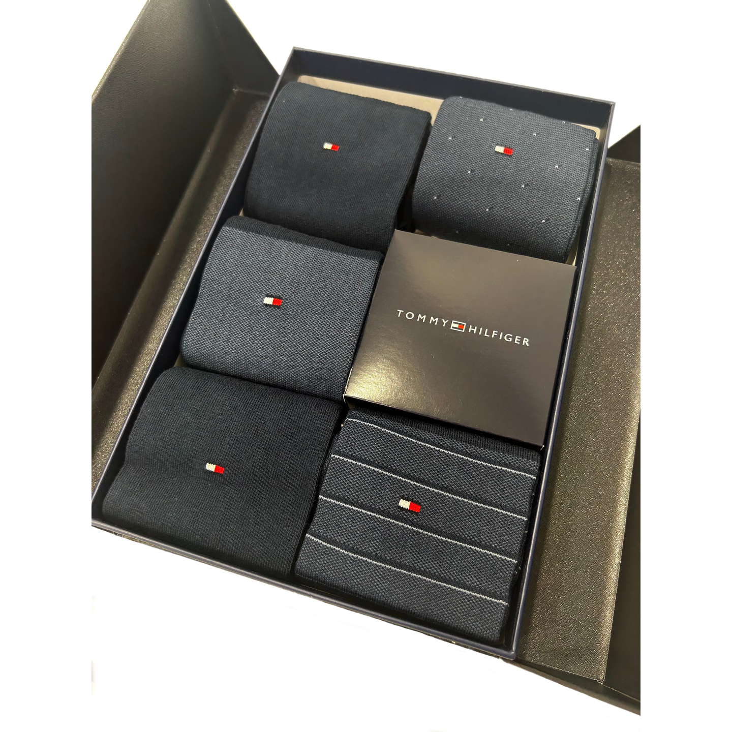 Box set of navy socks with small embroidered logo and subtle patterns, gift presentation